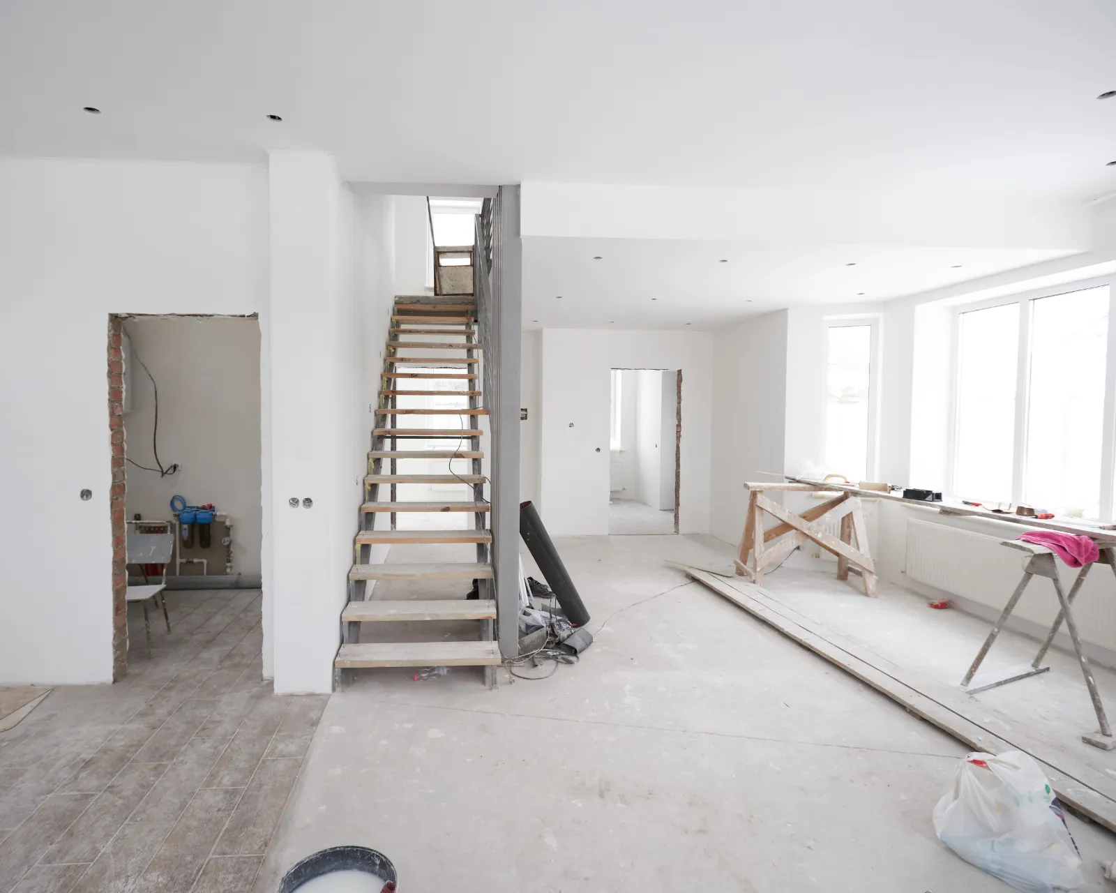 Gestript interieur tijdens een totaalrenovatie, met kale chape en nieuw pleisterwerk